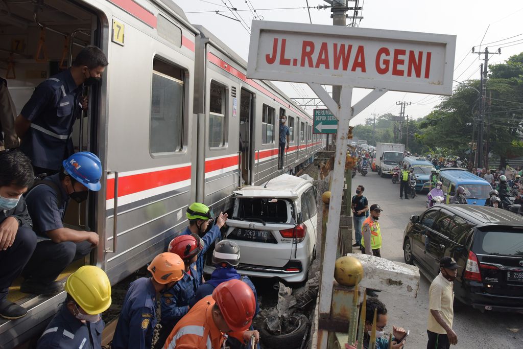 Sejumlah petugas berusaha mengevakuasi mobil Honda Mobilio yang tertabrak KRL Commuterline KA 1077 (Bogor-Jakarta Kota) di kawasan Rawageni, Ratu Jaya, Cipayung, Depok, Jabar, Rabu (20/4/2022). Kecelakaan yang terjadi di perlintasan sebidang itu menyebabkan terganggunya perjalanan KRL karena kereta harus melaju di satu jalur secara bergantian. ANTARA FOTO/Andika Wahyu/tom.