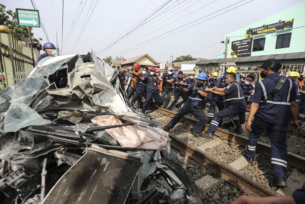 Sejumlah petugas melakukan evakuasi mobil yang tertabrak KRL di kawasan Rawageni, Cipayung, Depok, Jawa Barat, Rabu (20/4/2022). Kecelakaan yang terjadi antara KRL Commuterline KA 1077 (Bogor-Jakarta Kota) dengan mobil itu mengakibatkan terganggunya perjalanan KRL serta satu orang korban dibawa ke rumah sakit. ANTARA FOTO/Asprilla Dwi Adha/tom.