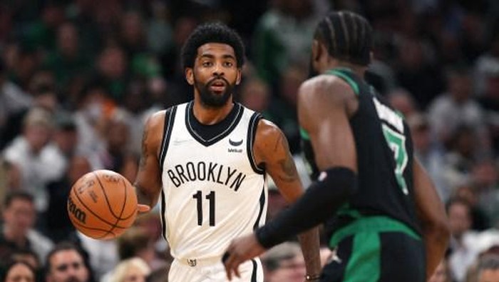 (FILES) In this file photo taken on April 17, 2022, Kyrie Irving, #11 of the Brooklyn Nets, dribbles downcourt against Jaylen Brown, #7 of the Boston Celtics, during the first quarter of Round 1 Game 1 of the 2022 NBA Eastern Conference Playoffs at TD Garden in Boston, Massachusetts. - Brooklyn Nets guard Kyrie Irving was fined $50,000 by the NBA on April 19, 2022, for directing obscene gestures and profane language at spectators, the league announced. (Photo by Maddie Meyer / GETTY IMAGES NORTH AMERICA / AFP)