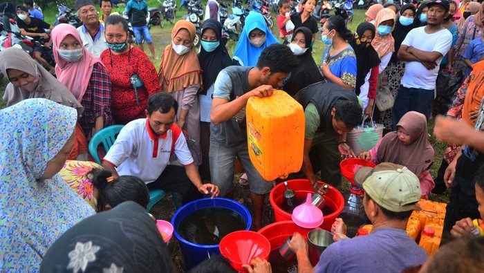 Warga antre membeli minyak goreng curah saat operasi pasar minyak goreng curah di Lapangan Desa Megawon, Kudus, Jawa Tengah, Rabu (20/4/2022). Operasi pasar yang digelar pemerintah desa setempat itu menyediakan sebanyak 8.000 liter bagi masyarakat umum dengan harga lebih murah dari pasaran yakni Rp14 ribu per liter guna meringankan beban masyarakat jelang lebaran. ANTARA FOTO/Yusuf Nugroho/wsj.