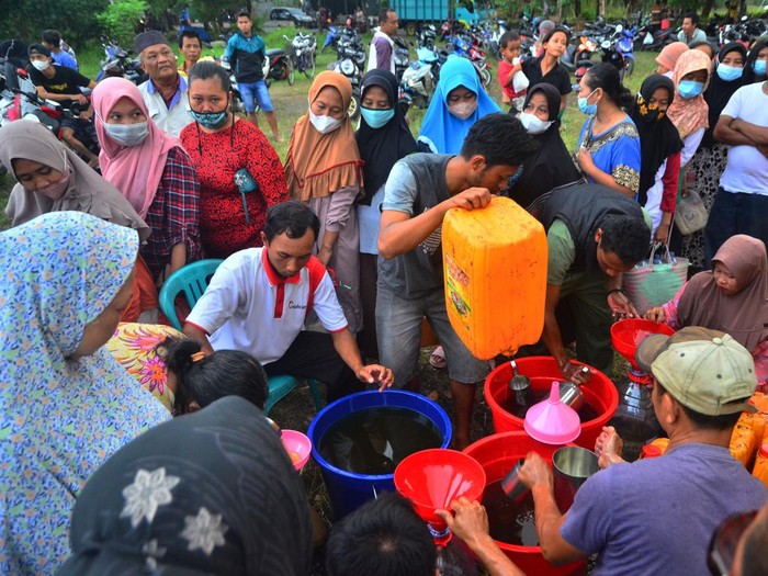 Warga antre membeli minyak goreng curah saat operasi pasar minyak goreng curah di Lapangan Desa Megawon, Kudus, Jawa Tengah, Rabu (20/4/2022). Operasi pasar yang digelar pemerintah desa setempat itu menyediakan sebanyak 8.000 liter bagi masyarakat umum dengan harga lebih murah dari pasaran yakni Rp14 ribu per liter guna meringankan beban masyarakat jelang lebaran. ANTARA FOTO/Yusuf Nugroho/wsj.