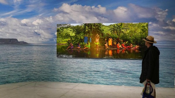 Seorang pria melihat instalasi Paradise Camp karya seniman Yuki Kihara di paviliun Selandia Baru.