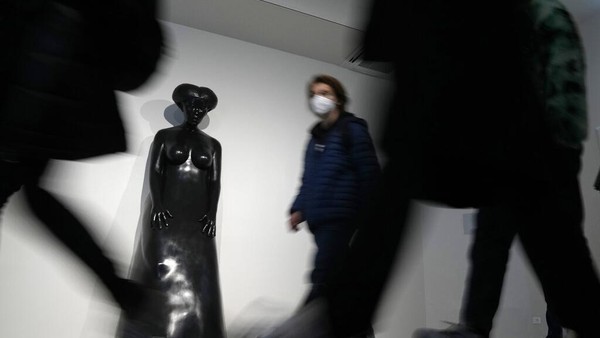 Orang-orang berjalan melewati patung Sharifa bagian dari instalasi Kedaulatan karya seniman Simone Leigh, di paviliun Amerika Serikat. Dalam festival tahun ini, pengarah artistik Cecilia Alemani ditunjuk menjadi kurator.