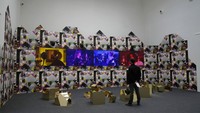 Seorang pria berdiri di samping bagian instalasi Feeling Her Way karya seniman Sonia Boyce, di paviliun Inggris Raya. Tema dari pameran tahun ini bertajuk The Milk of Dreams yang diambil dari buku absurd karya seniman surealis, Leonora Carrington pada 1950-an.