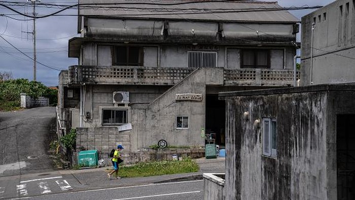 Menyusuri Yonaguni, Pulau Paling Barat di Jepang YONAGUNI, JAPAN - APRIL 13: A boy walks past houses on April 13, 2022 on Yonaguni, Japan. As Japans westernmost inhabited island, just 111 kilometres away from Taiwan and located close to the disputed Senkaku Islands, Yonaguni has seen an increased military presence as the Japanese government looks to ward off Chinese activity in nearby territory claimed by both countries. Japans Air Self-Defense Force has recently announced that it will permanently station a mobile radar unit on the island, adding to an existing military radar station which allows monitoring of the Chinese mainland and tracking of Chinese ships and aircraft in the area. Japans Ground Self-Defense Force also plans to deploy an electronic warfare unit to Yonaguni in 2023. (Photo by Carl Court/Getty Images)