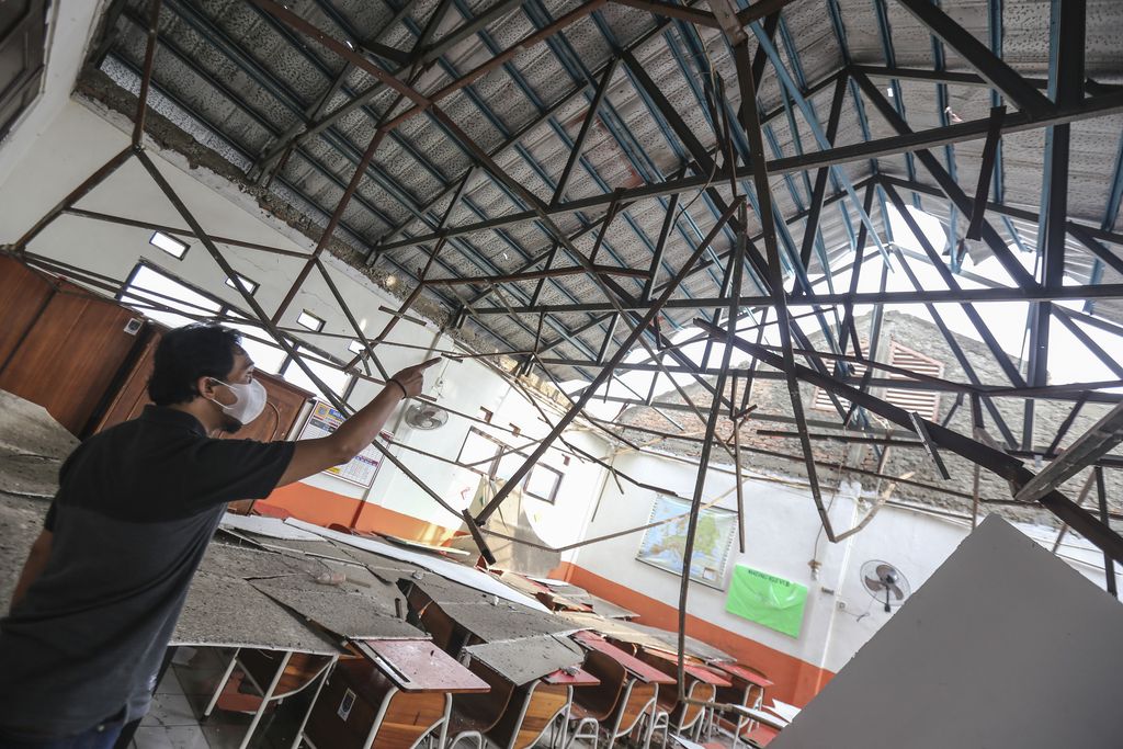 Seorang pekerja melihat kondisi ruang kelas yang atapnya ambruk di SDN Pancoranmas 3, Depok, Jawa Barat, Rabu (20/4/2022). Dua ruangan kelas di SDN Pancoranmas 3 tersebut mengalami kerusakan pada bagian atap bangunan yang ambruk akibat hujan deras disertai angin kencang pada Selasa (19/4) sore. ANTARA FOTO/Asprilla Dwi Adha/tom.