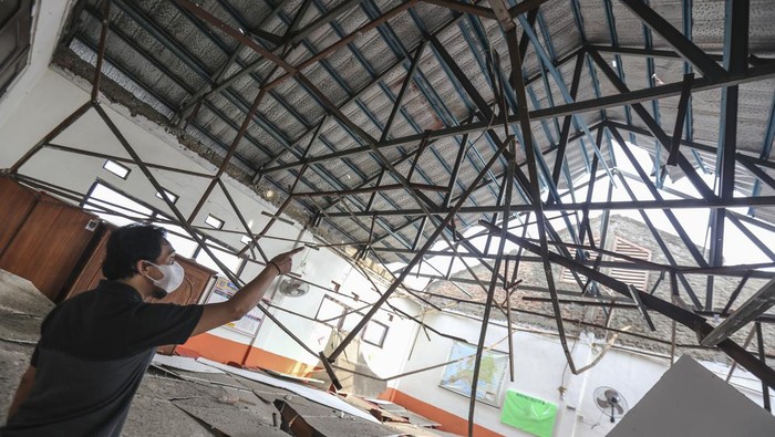 Seorang pekerja melihat kondisi ruang kelas yang atapnya ambruk di SDN Pancoranmas 3, Depok, Jawa Barat, Rabu (20/4/2022). Dua ruangan kelas di SDN Pancoranmas 3 tersebut mengalami kerusakan pada bagian atap bangunan yang ambruk akibat hujan deras disertai angin kencang pada Selasa (19/4) sore. ANTARA FOTO/Asprilla Dwi Adha/tom.