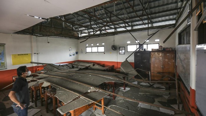 Seorang pekerja melihat kondisi ruang kelas yang atapnya ambruk di SDN Pancoranmas 3, Depok, Jawa Barat, Rabu (20/4/2022). Dua ruangan kelas di SDN Pancoranmas 3 tersebut mengalami kerusakan pada bagian atap bangunan yang ambruk akibat hujan deras disertai angin kencang pada Selasa (19/4) sore. ANTARA FOTO/Asprilla Dwi Adha/tom.
