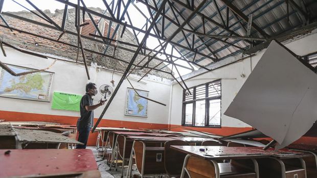 Seorang pekerja melihat kondisi ruang kelas yang atapnya ambruk di SDN Pancoranmas 3, Depok, Jawa Barat, Rabu (20/4/2022). Dua ruangan kelas di SDN Pancoranmas 3 tersebut mengalami kerusakan pada bagian atap bangunan yang ambruk akibat hujan deras disertai angin kencang pada Selasa (19/4) sore. ANTARA FOTO/Asprilla Dwi Adha/tom.