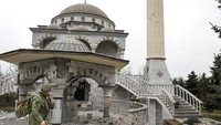 Seorang prajurit milisi Republik Rakyat Donetsk berjalan melewati masjid yang rusak akibat perang Rusia-Ukraina di kawasan Mariupol, Selasa (19/4/2022). (AP Photo/Alexei Alexandrov).