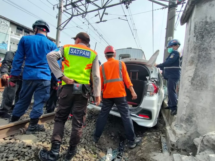 Petugas Evakuasi Mobil Tertabrak KRL di Perlintasan Citayam Depok