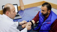 Ahmed Abu Hamda (36), yang kehilangan tangan kanannya pada 2007 dan dipasangi anggota gerak myoelectric, lengannya diperiksa di Rumah Sakit Rehabilitasi dan Prostetik Sheikh Hamad Bin Khalifa Al Thani di Jalur Gaza utara (13/4/2022).
