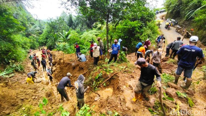Relawan dan warga melakukan penanganan material longsor yang menimbul jalan di Desa Girimukti Kecamatan Pasirkuda