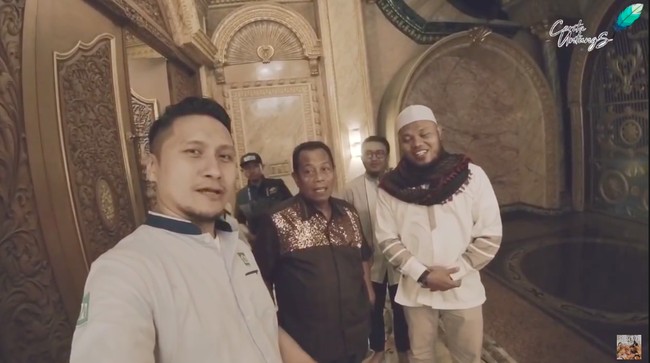 Inilah sosok Hasim Hadado (berdiri di tengah) yang diketahui berprofesi sebagai pengusaha jasa konstruksi. Ditanya Arie soal biaya pembangunan rumahnya, Hasim enggan mengungkapnya. Yang pasti ini semua titipan Allah, katanya. (Foto: YouTube/CeritaUntungs)