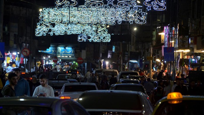People walk outside a mosque along a street decorated for the holy month of Ramadan in Amman, Jordan, April 7, 2022. Picture taken April 7, 2022. REUTERS/Muath Freij