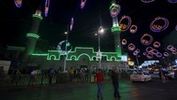 Orang-orang berjalan di luar masjid di sepanjang jalan yang didekorasi untuk bulan suci Ramadan.