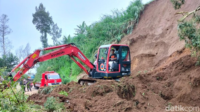 Alat berat BPBD Boyolali menyingkirkan material longsor yang menutup jalan Selo-Ampel, Boyolali, Kamis (21/4/2022).