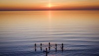 Momen senja ini dimanfaatkan para pengunjung untuk bermai paddle board.