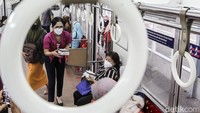 Sejumlah petugas membagikan takjil kepada penumpang commuterline.