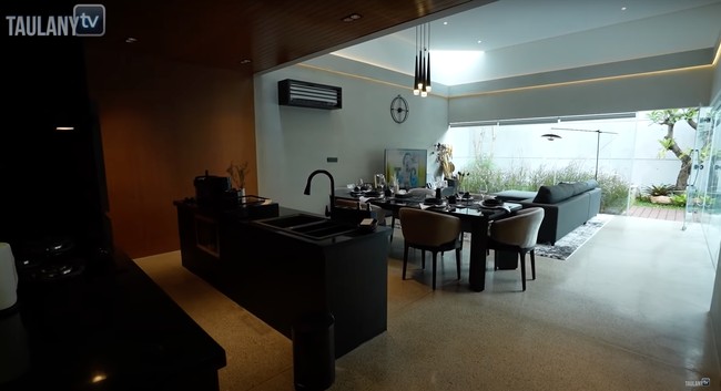 Dengan luas 350 meter persegi, rumah baru milik Desta itu terlihat begitu mewah. Perpaduan warna hitam, putih, dan coklat menambah kesan elegan di dalam ruangan rumah. Untuk mempercantiknya, Desta pun menambahkan lampu gantung di atas meja makannya. Foto: YouTube/Taulany TV