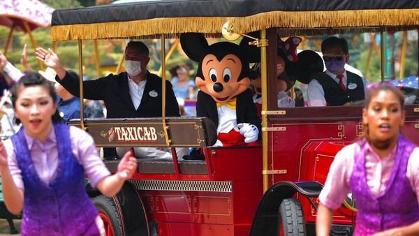 Penari dan karakter ikonik Mickey Mouse tampil dalam parade di Hong Kong Disneyland. Para pekerja yang berpakaian seperti karakter Disney bertugas berpose untuk difoto, tetapi pengunjung harus berada lebih dari satu meter ketika mereka mengambil foto