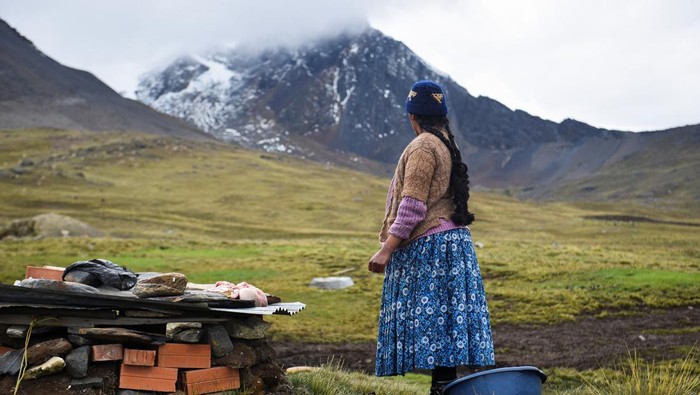 EARTH-DAY/BOLIVIA-GLACIERS A woman prepares food at the inauguration of tourist season at the Charquini glacier, as scientists and climbers battle over the future of the controversial lure for tourists, outside of El Alto, Bolivia April 8, 2022. Picture taken April 8, 2022. REUTERS/Claudia Morales