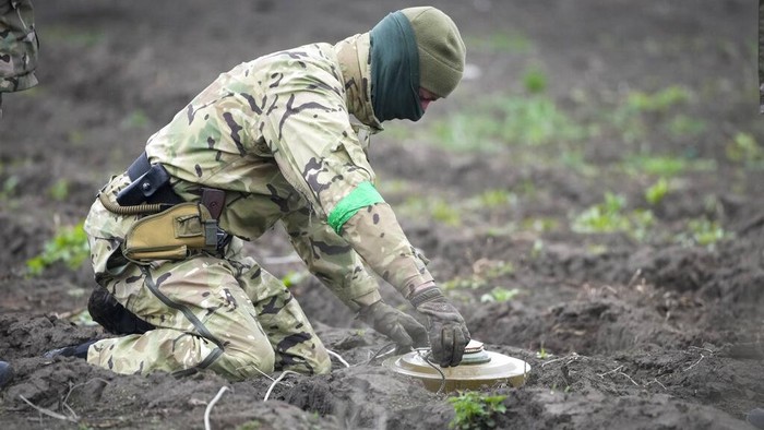 Ukrainian Interior ministry sappers collect explosives in a hole to detonate them near a mine field in the village of Moshchun, close to Kyiv, Ukraine, Tuesday, April 19, 2022. Russia ratcheted up its battle for control of Ukraine’s eastern industrial heartland on Tuesday, intensifying assaults on cities and towns along a front hundreds of miles long in what officials on both sides described as a new phase of the war. (AP Photo/Efrem Lukatsky)