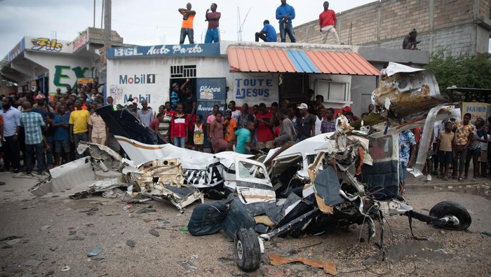 Sekitar 5 orang tewas usai pesawat kecil menabrak truk saat mencoba mendarat di Haiti. Warga berdatangan ke lokasi kecelakaan untuk melihat puing pesawat.