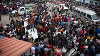Warga berkumpul untuk melihat puing pesawat yang jatuh di kawasan Port-au-Prince, Haiti, Rabu (20/4/2022) waktu setempat.