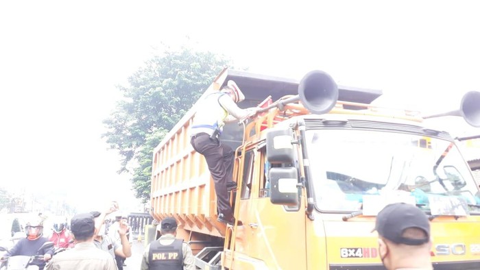 Polisi naik ke atas truk untuk mengantisipasi penyusup demo 21 April