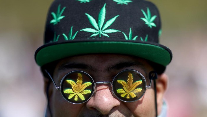 Potret Orang-orang di London Bebas Menghisap di Hari Libur Ganja A man poses for a photo during a demonstration to mark the informal cannabis holiday in Hyde Park, London, Britain, April 20, 2022. REUTERS/Tom Nicholson