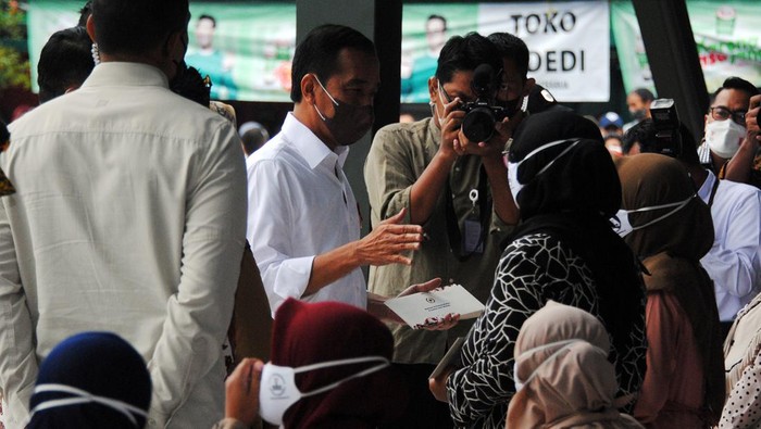 Presiden Joko Widodo berbincang dengan warga saat membagikan Bantuan Langsung Tunai (BLT) subsidi minyak goreng di Pasar Rakyat Cisarua, Kabupaten Bogor, Jawa Barat, Kamis (21/4/2022). Presiden membagikan uang tunai BLT minyak goreng sebesar Rp300 ribu, bantuan modal usaha sebesar Rp1.200.000 dan sembako untuk Keluarga Penerima Manfaat (KPM) Program Keluarga Harapan (PKH) di wilayah Kota dan Kabupaten Bogor, Jawa Barat. ANTARA FOTO/Arif Firmansyah/foc.