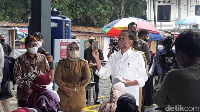 Presiden Jokowi menyerahkan BLT minyak goreng kepada PKL dan kepada penerima PKH di 4 pasar di Kabupaten Bogor dan Kota Bogor. (M Sholihin/detikcom)