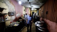 Pemeluk agama Kristen, Gameel Kamal (tengah-berbaju biru) melihat proses memasak makanan yang akan dibagikan sebagai hidangan berbuka puasa umat muslim di Kairo, Mesir, Rabu (20/4/2022).
