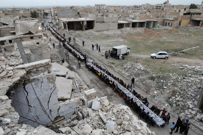 People gather during Iftar (breaking fast), during the holy month of Ramadan, in the town of Tadef, on a frontline between Russian-backed Syrian government forces and Turkish-backed Syrian rebel-held territory, in northern Syria April 18, 2022. Picture taken April 18, 2022.  REUTERS/Khalil Ashawi