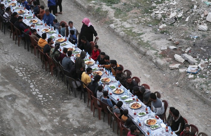 People gather during Iftar (breaking fast), during the holy month of Ramadan, in the town of Tadef, on a frontline between Russian-backed Syrian government forces and Turkish-backed Syrian rebel-held territory, in northern Syria April 18, 2022. Picture taken April 18, 2022.  REUTERS/Khalil Ashawi