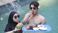Meski hanya pura-pura di Bali, mereka menikmati sekali waktu berenang sambil menikmati floating breakfast. Terlihat ada ragam buah hingga roti yang jadi suguhan.