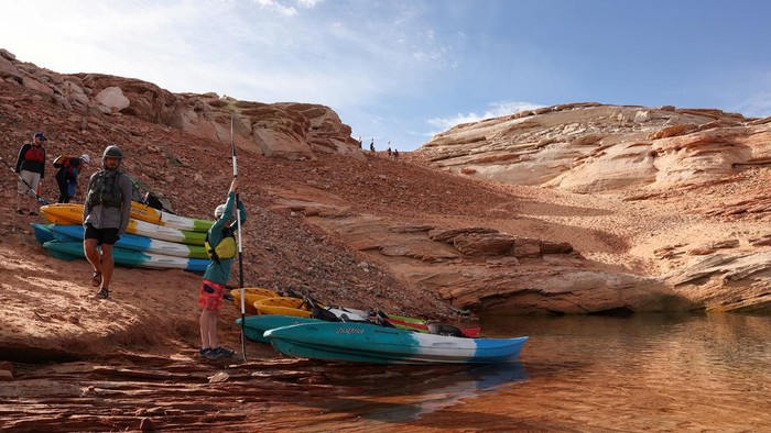 USA-CLIMATECHANGE/WATER Kayaks are seen on the shore of Lake Powell, where water levels have declined dramatically to lows not seen since it was filled in the 1960s as growing demand for water and climate change shrink the Colorado River and create challenges for business owners and recreation in Page, Arizona, U.S., April 19, 2022. REUTERS/Caitlin Ochs