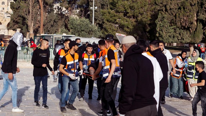 Palestinian rescue workers attend to an injured man during clashes with Israeli security forces at the compound that houses Al-Aqsa Mosque, known to Muslims as Noble Sanctuary and to Jews as Temple Mount, in Jerusalem's Old City April 22, 2022. REUTERS/Ammar Awad