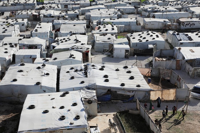 Pengungsi Suriah A Syrian refugee reads the Koran during the holy month of Ramadan at an informal camp in Deir Zenoun, in the Bekaa valley, Lebanon April 19, 2022. Picture taken April 19, 2022. REUTERS/Mohamed Azakir