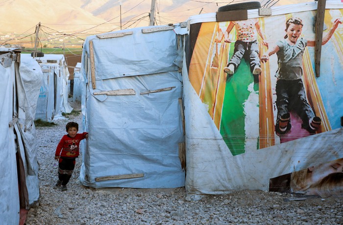 Pengungsi Suriah A Syrian refugee reads the Koran during the holy month of Ramadan at an informal camp in Deir Zenoun, in the Bekaa valley, Lebanon April 19, 2022. Picture taken April 19, 2022. REUTERS/Mohamed Azakir