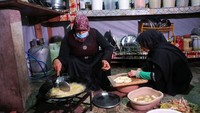 Perempuan menyiapkan menu berbuka puasa berupa kentang goreng di tenda pengungsian. Meski sama-sama muslim, pemerintah dan pemberontak di Suriah saling berperang dengan alasan masing-masing.