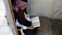 Pengungsi melewati bulan Ramadan dengan membaca Al-Quran di tenda pengungsian.