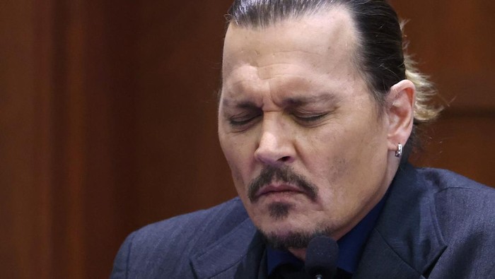 Actor Johnny Depp watches a pre-recorded deposition testimony of Christian Carino at the Fairfax County Circuit Court in Fairfax, Va., Wednesday, April 27, 2022. Depp sued his ex-wife actress Amber Heard for libel in Fairfax County Circuit Court after she wrote an op-ed piece in The Washington Post in 2018 referring to herself as a public figure representing domestic abuse. (Jonathan Ernst/Pool Photo via AP)