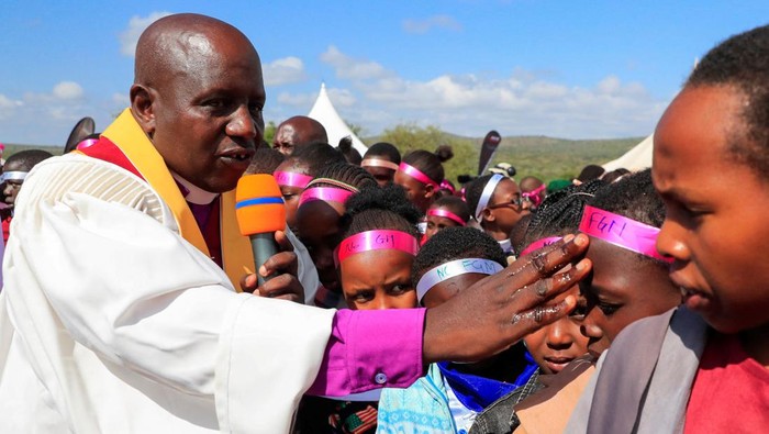 Perempuan di Kenya Rayakan Kedewasaan Usai Ritual Sunat Perempuan Dilarang Felistar Titian from the indigenous Maasai community carries oil to bless the girls during an alternative rite of passage into adulthood, shunning the traditional genital mutilation which has been outlawed in Kiloh village of Imaroro location in Kajiado county, Kenya April 8, 2022. Picture taken April 8, 2022. REUTERS/Thomas Mukoya