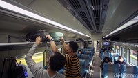 Penumpang menata barang-barang di gerbong kereta.