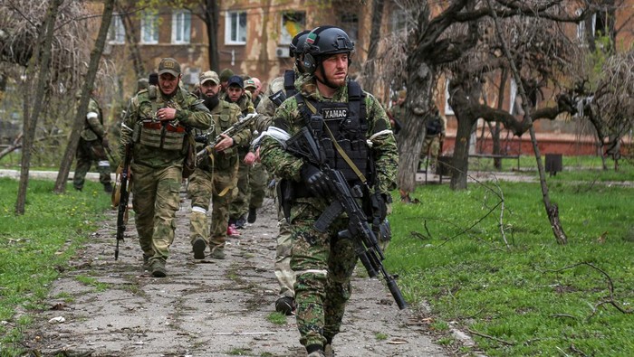 Putin Minta Mariupol Diblokade, Petarung Chechnya Ikut Turun Fighters of the Chechen special forces unit, led by Russia's State Duma member Adam Delimkhanov, walk near the administration building of Azovstal Iron and Steel Works during Ukraine-Russia conflict in the southern port city of Mariupol, Ukraine April 21, 2022. REUTERS/Chingis Kondarov