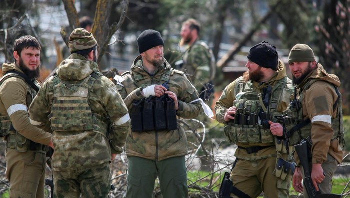 Putin Minta Mariupol Diblokade, Petarung Chechnya Ikut Turun Fighters of the Chechen special forces unit, led by Russia's State Duma member Adam Delimkhanov, walk near the administration building of Azovstal Iron and Steel Works during Ukraine-Russia conflict in the southern port city of Mariupol, Ukraine April 21, 2022. REUTERS/Chingis Kondarov