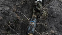 Pencari ranjau Ukraina bersiap menghancurkan bom penerbangan yang gagal meledak di wilayah Kyiv, Kamis (21/4/2022). (Mykola Tymchenko/Reuters)