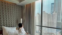 Menyambut pagi hari, Anastasya yang baru bangun tidur langsung menyeruput segelas minuman hangat. Masih mengenakan bathrobe, dirinya menghadap keluar jendela untuk menikmati suasana. Foto: Instagram/anastasyakh